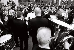 Knottingley Silver Band, surrounded by a crowd, prepare to play "Gresford: The Miners' Hymn".